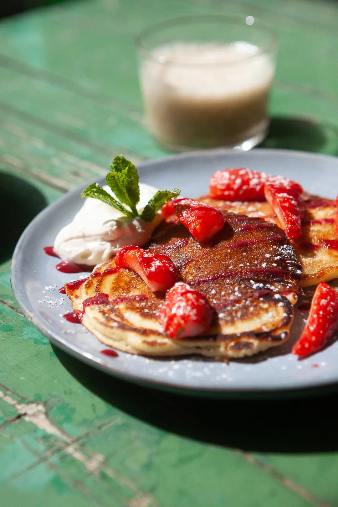 Pancakes aux fraises et crème, sur la table verte, au brunch du dimanche