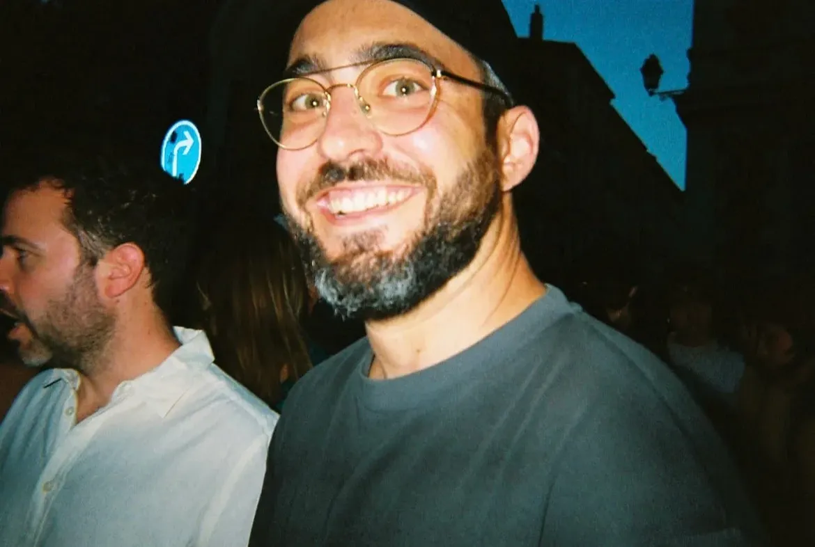 Un invité à lunettes rondes, tout sourire, un soir de fête place du Peyrou